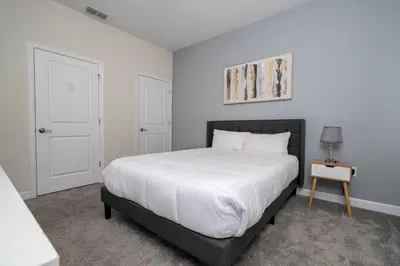 a bedroom with a large bed and a table at 4337 QS - Charming Hideaway in Kissimmee