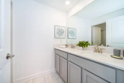 a white bathroom with a sink and a mirror at 4220AA TOWNHOUSE 4 BEDROOM 3 BATHS + PRIVATE POOL in Kissimmee