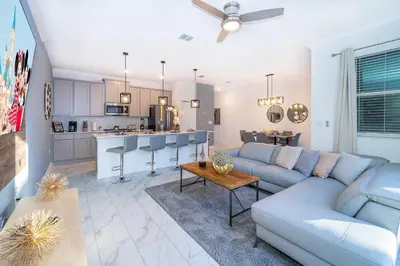a living room with a couch and a kitchen at 4220AA TOWNHOUSE 4 BEDROOM 3 BATHS + PRIVATE POOL in Kissimmee