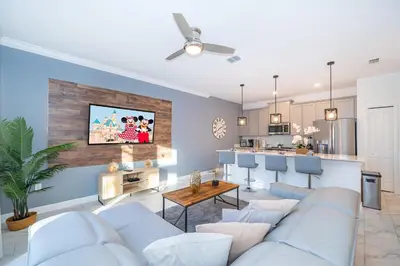 a living room with a couch and a kitchen at 4220AA TOWNHOUSE 4 BEDROOM 3 BATHS + PRIVATE POOL in Kissimmee