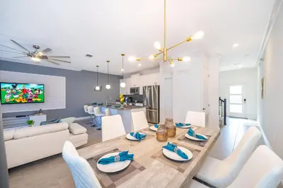a dining room and living room with a table and chairs at 4435LT TOWNHOUSE 4 BEDROOMS & 3 BATHROOMS + POOL in Kissimmee