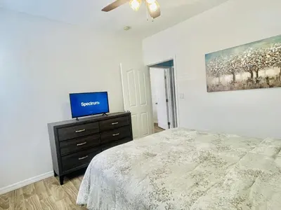 a bedroom with a bed and a tv on a dresser at Cozy Condo Minutes Away From Disney in Kissimmee