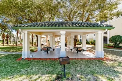 a gazebo with picnic tables in a park at Cozy Condo Minutes Away From Disney in Kissimmee