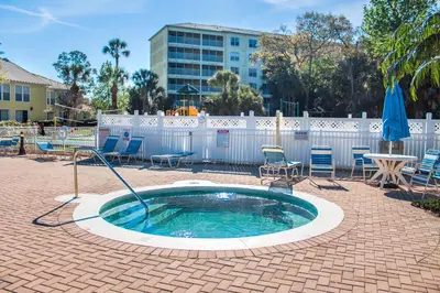 a small pool with chairs and a table and umbrella at Barefoot'n Resort Kissimmee Orlando in Orlando