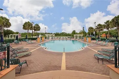 a large swimming pool with chairs around it at 4 Bedroom 3 Bathroom Villas At SevenDwarfs 12-108 in Kissimmee