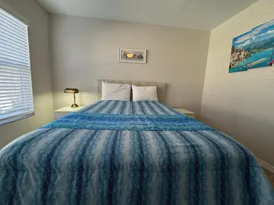 a bedroom with a bed with a blue comforter at 3 Bedroom 2 Bathroom Villas At SevenDwarfs 27-106 in Kissimmee
