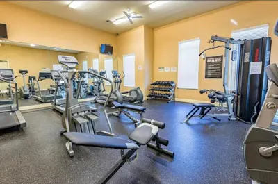 a gym with several treadmills and cardio machines at 3 Bedroom 2 Bathroom Villas At SevenDwarfs 27-106 in Kissimmee