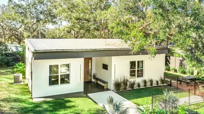 a small white house with a yard at Florida HappyNest Secluded Luxury Guesthouse in Kissimmee