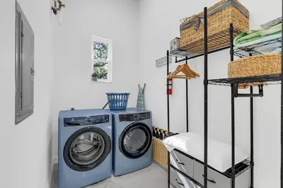 a washing machine in a laundry room with a shelf at Florida HappyNest Secluded Luxury Guesthouse in Kissimmee