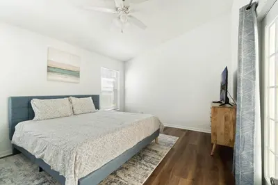 a bedroom with a bed and a ceiling fan at Luxury 4-Bedroom Home with Private Pool, Jacuzzi, AC, Wi-Fi, Cable TV, 5 Minutes from Disney in Kissimmee