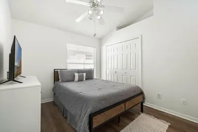 a bedroom with a bed and a ceiling fan at Luxury 4-Bedroom Home with Private Pool, Jacuzzi, AC, Wi-Fi, Cable TV, 5 Minutes from Disney in Kissimmee