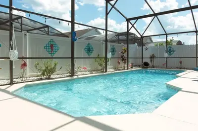 a large swimming pool with a metal roof at Indian Creek Vacation Home Close to Disney villa in Orlando
