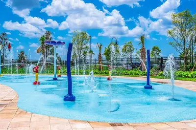 a pool with water fountains in a park at Dream Vacation Home with Lake View, Pool, more, and Walking Distance to Resort in Kissimmee
