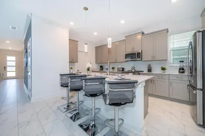 a kitchen with a large island with bar stools at 4338JE VILLA 5 BED/5 BA in Kissimmee
