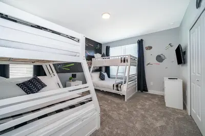 a bedroom with two bunk beds and a tv at 4338JE VILLA 5 BED/5 BA in Kissimmee