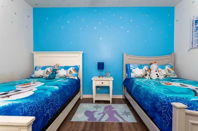 two beds in a room with blue walls at happy place in Kissimmee