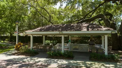 a gazebo with a table and chairs in a park at happy place in Kissimmee