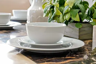 a white coffee cup and saucer on a table at Lake Berkley Home: Pool, Lakefront & near Disney in Kissimmee