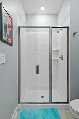 a glass shower door in a bathroom with a toilet at Lakeview 5BR with Game Room and Pool, Near Disney in Kissimmee