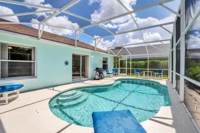 a swimming pool with a patio and a house at 10 Min from Disney Themed 2 Bd Private Pool in Orlando