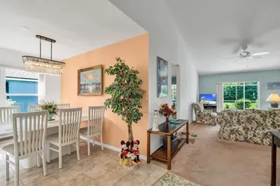 a living room with a table and a dining room at 10 Min from Disney Themed 2 Bd Private Pool in Orlando
