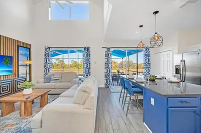 a kitchen and a living room with blue cabinets at The Ultimate Family Getaway in Kissimmee