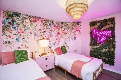 two beds in a room with a flower wall at The Ultimate Family Getaway in Kissimmee