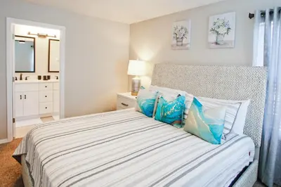 a bedroom with a bed with blue and white pillows at PN Orlando Vacation Home in Kissimmee