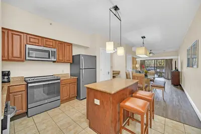 a kitchen with wooden cabinets and stainless steel appliances at Orlando Getaway at Floridays Resort in Orlando