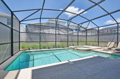 a house with a swimming pool with a glass wall at Spacious 6 Bed Home with Pool in Prime Storey Lake Location in Kissimmee