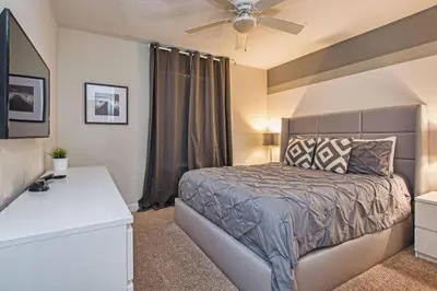 a bedroom with a bed and a ceiling fan at Spacious 6 Bed Home with Pool in Prime Storey Lake Location in Kissimmee