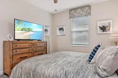 a bedroom with a flat screen tv on a dresser at 9 Bed Home Pool Best Location Storey Lake in Kissimmee