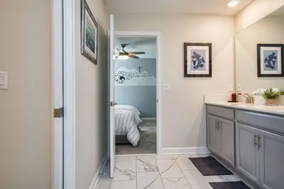 a bathroom with a sink and a door with a mirror at 9 Bed Home Pool Best Location Storey Lake in Kissimmee