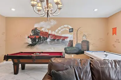 a living room with a train painting on the wall at 9 Bed Home Pool Best Location Storey Lake in Kissimmee