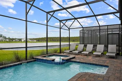 a swimming pool with chairs and a glass house at 9 Bed Home Themed Rooms Pool Storey Lake in Kissimmee