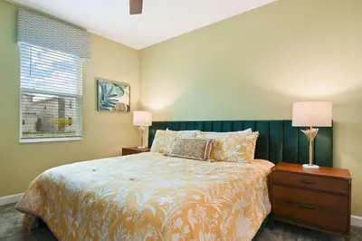 a bedroom with a bed and two lamps and a window at 9 Bed Home Themed Rooms Pool Storey Lake in Kissimmee