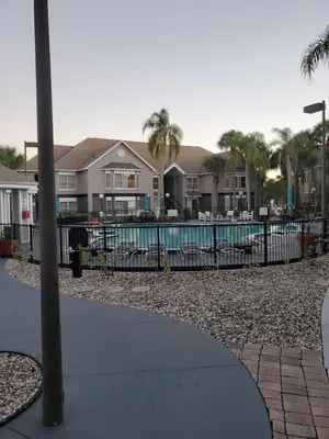 a fence with a pool in front of some houses at Nice 2 Miles from DISNEY Condo 1 Bedroom 1 Bath in Orlando