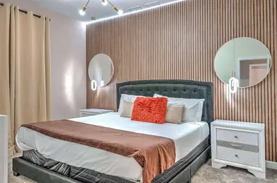 a bedroom with a large bed and a mirror at 2852 Ultimate Retreat for your family 9 Bedrooms in Kissimmee