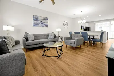 a living room with a couch and a table and chairs at Epic Universe New Beautiful Townhome - 4033 in Orlando