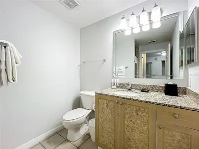 a bathroom with a toilet and a sink and a mirror at Spacious 3 Bed 3 Bath Luxury Condo 5 min from Disney in Orlando