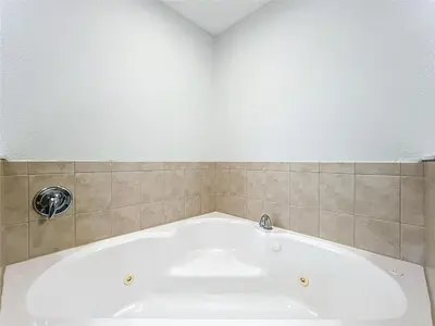 a bath tub in a bathroom with a tiled wall at Spacious 3 Bed 3 Bath Luxury Condo 5 min from Disney in Orlando