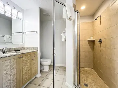 a bathroom with a toilet and a glass shower at Spacious 3 Bed 3 Bath Luxury Condo 5 min from Disney in Orlando