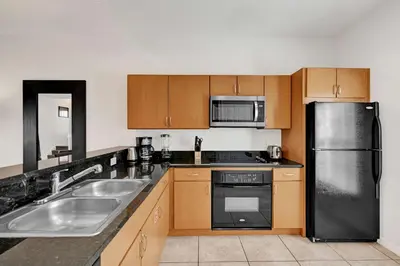 a kitchen with a stainless steel refrigerator and a sink at Upstay Spacious 3BR Home w Resort Access in Kissimmee