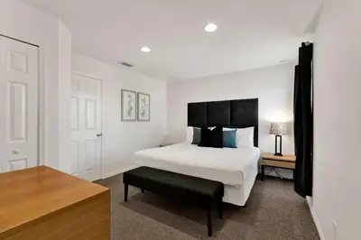 a bedroom with a white bed and a black headboard at Upstay Spacious 3BR Home w Resort Access in Kissimmee