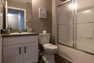 a bathroom with a toilet and a sink and a shower at Cozy Family 3BR Townhouse Perfect Stay for 6 Guests in Kissimmee