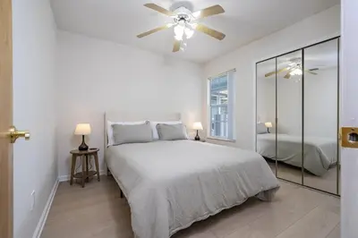 a white bedroom with a bed and a ceiling fan at Family Apt very close to Disney in Kissimmee