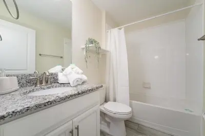 a white bathroom with a sink and a toilet at Luxury 5 Bedroom 5 bath private pool Home 279 in Kissimmee