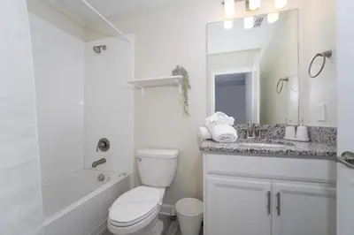 a white bathroom with a toilet and a sink at Luxury 5 Bedroom 5 bath private pool Home 279 in Kissimmee