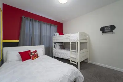 a bedroom with two bunk beds and a red wall at Luxury 5 Bedroom 5 bath private pool Home 279 in Kissimmee