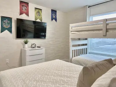 a bedroom with a bed and a flat screen tv at Beautiful 4 bedroom 3 bath pool Townhome 280 in Kissimmee